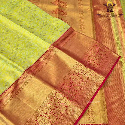 A refreshing lime green body paired with a rich golden tissue pallu and red zari border Saree