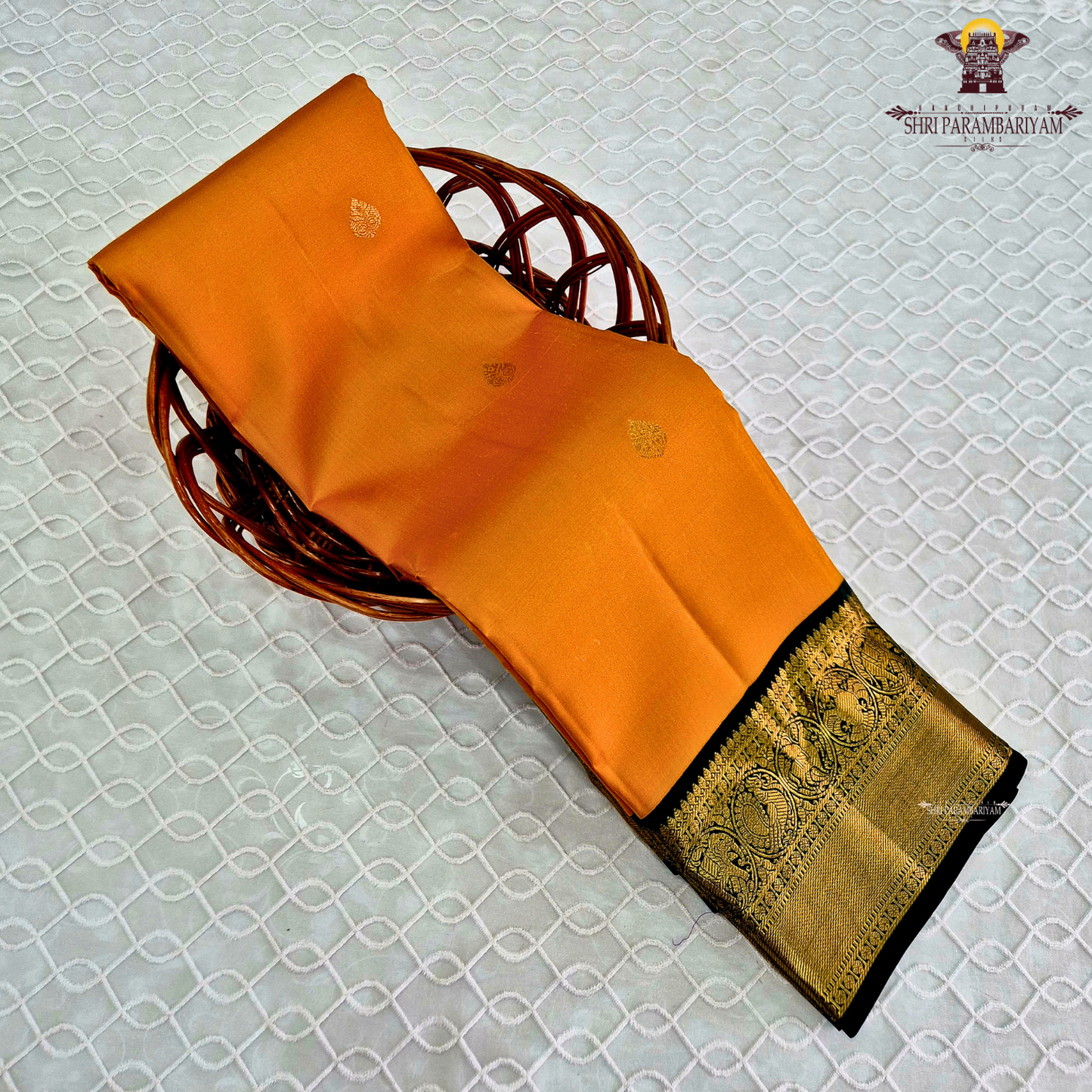 A vibrant mustard orange body highlighted with delicate zari buttas Saree