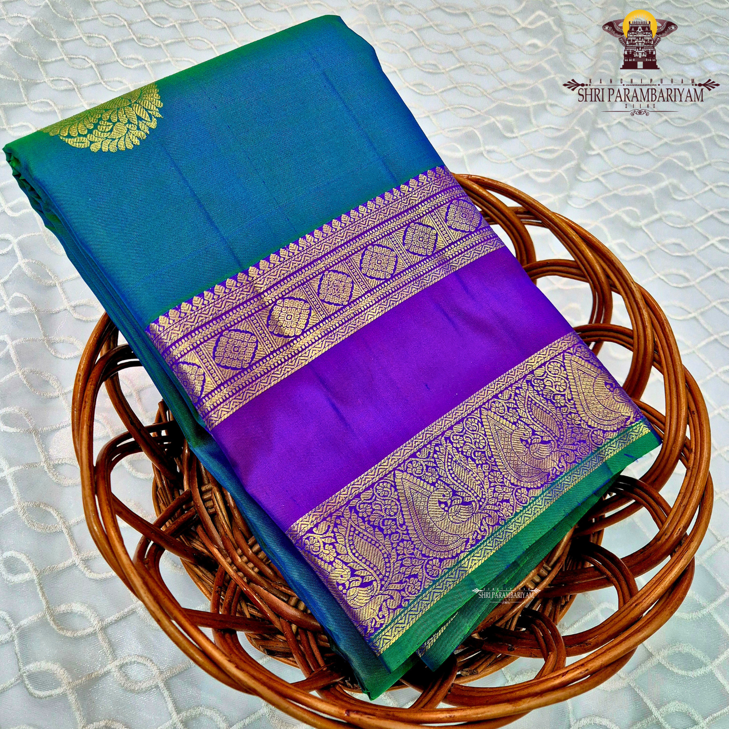 A elegant teal blue (peacock blue) body with a rich contrast purple/violet border Saree