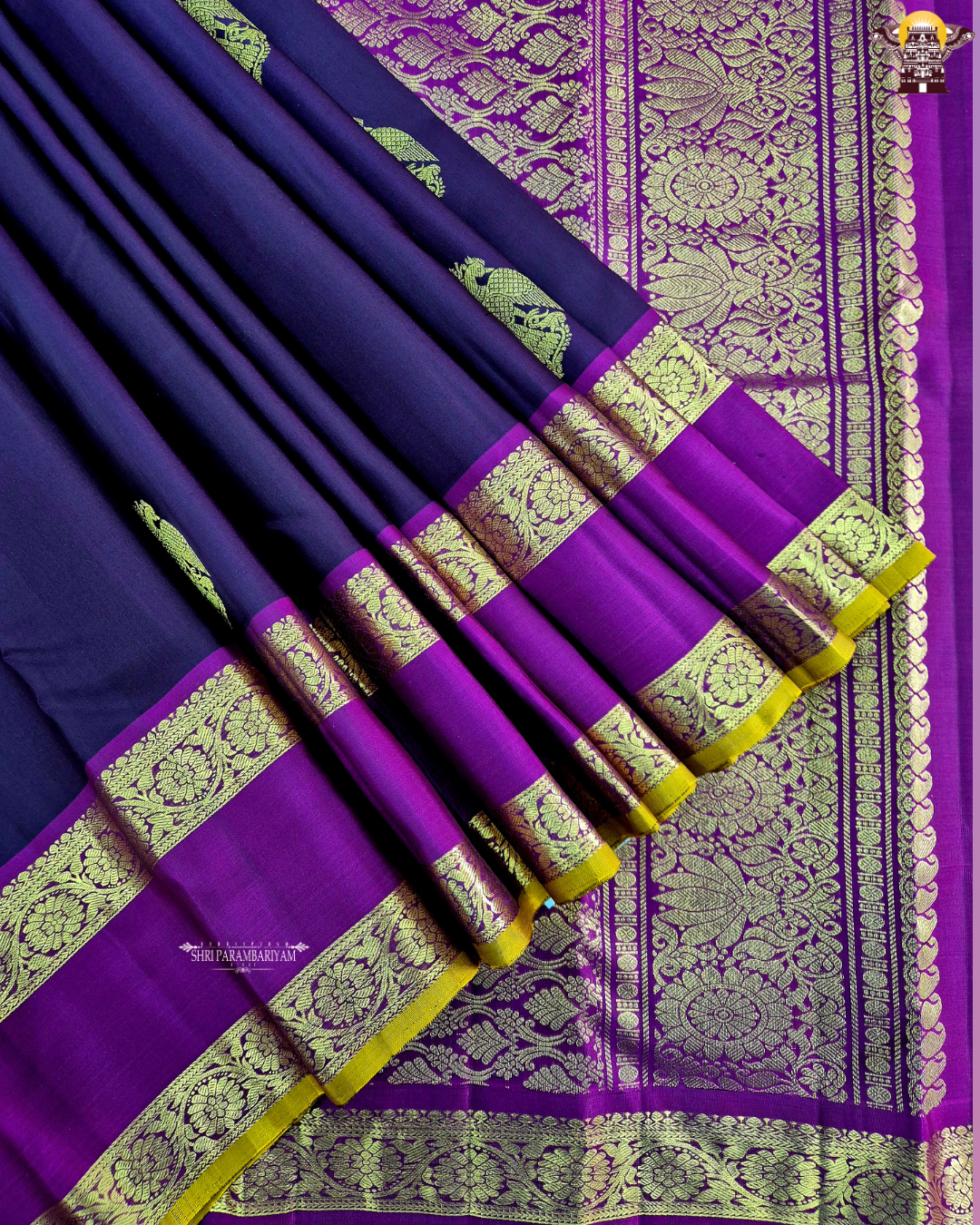 A rich deep violet / royal purple body paired with contrast magenta (pink) and antique gold tones Saree